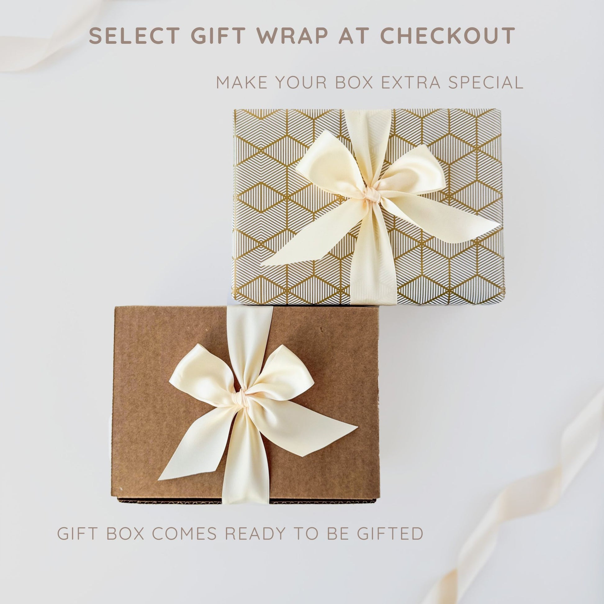 Two elegantly wrapped gift boxes, one in gold geometric patterned paper and the other in plain brown kraft paper, both tied with cream satin ribbons, with text reading 'Select gift wrap at checkout - Make your box extra special.